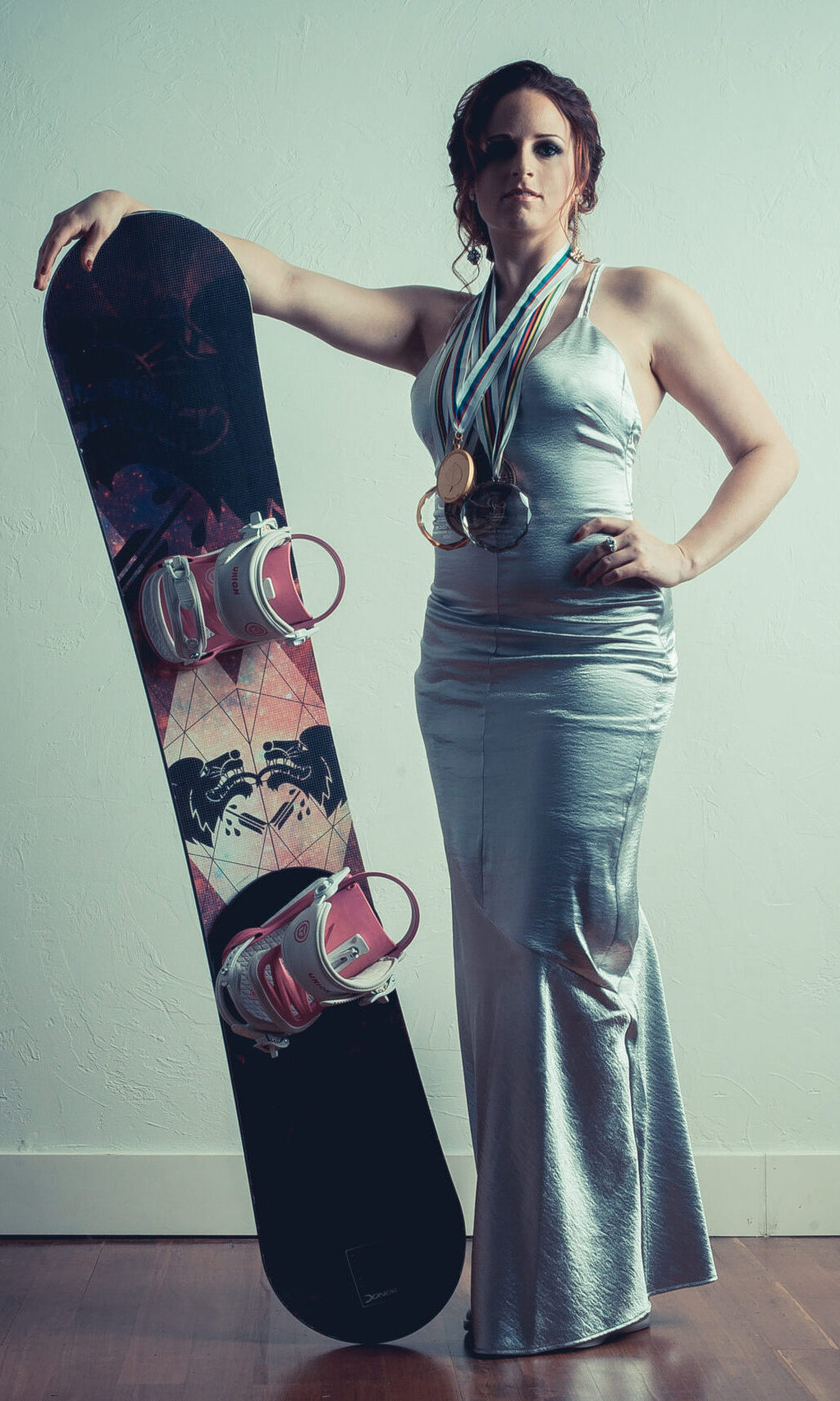 Nicole Roundy stands with custom Donek raceboard and world cup medals